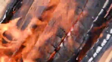 Şöminede ateş yanıyor. Izgarada çok sıcak kömür yanıyor ve 4K çözünürlük yanıyor.
