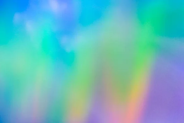 Blurred rainbow light refraction texture overlay effect for photo and mockups. Organic holographic flare on a white wall. Shadows for natural light effects.