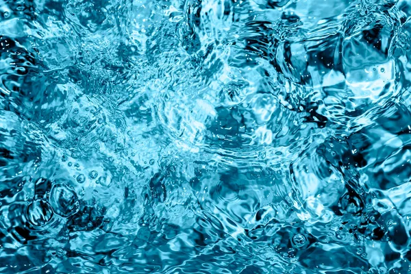 Modrý bazén nebo vířivka vody pozadí. Vlnky na modré průsvitné vodě v bazénu se světelným odrazem. Horní pohled. Letní prapor — Stock fotografie