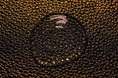 Altın deri arka planda izole edilmiş jel ya da su damlası. Üst Manzara. Virüs koruması ya da kozmetik konsepti. Serum dokusu kapat