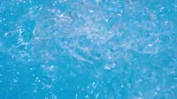 Spumeggiante acqua blu trasparente zampillante in vasca idromassaggio o piscina. Video a risoluzione Full HD al rallentatore. Getto decorativo o fontana d'acqua nella vasca idromassaggio. — Video Stock