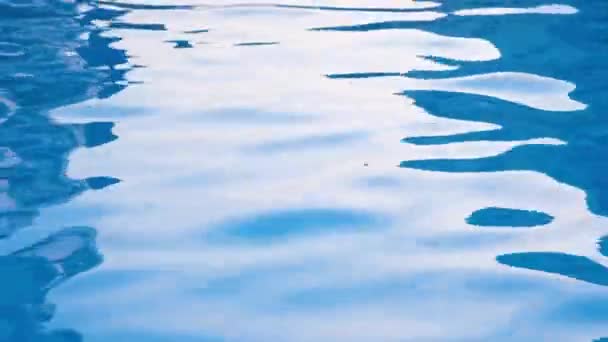 光の反射とスイミングプールで穏やかな純粋な透明な青い水。4k解像度ビデオ。プール内の水の質感. — ストック動画