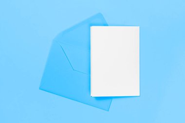 Mavi arkaplanda mavi zarf bulunan boş beyaz kart. Şablon ya da maket. Kopyalama alanı olan pankart