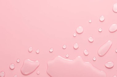 Bir damla su ve pastel pembe arka planda damlalar. Su dokusu kapanıyor. Arkaplan camı su damlalarıyla kaplı. Su kabarcıkları.