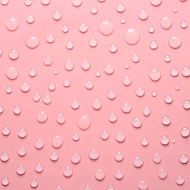 Pembe arka planda su damlaları var. Su dokusu kapanıyor. Arkaplan camı su damlalarıyla kaplı. Su kabarcıkları.