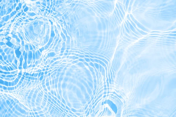 Surface of light blue transparent swimming pool water texture with circles on the water. Trendy abstract nature background. Water waves in sun light reflections
