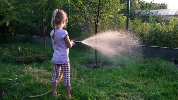 Küçük kızlar yazlığında bahçeyi suluyorlar. Bahçe konseptine dikkat et. Güneşe karşı ateş ediyorlar. Yavaş çekim Tam HD video. — Stok video