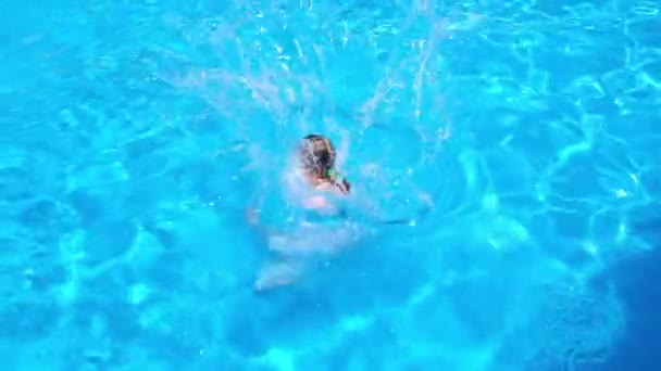 Glückliches Teenie-Mädchen, das bei einer Poolparty an einem sonnigen Sommertag ins Schwimmbad springt und springt. Videos in HD-Auflösung in Zeitlupe. Videobanner mit Kopierraum. — Stockvideo