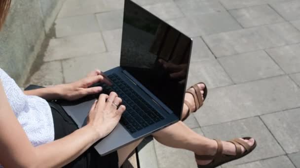 Das Mädchen beendete die Arbeit am Laptop und schloss ihn. Eine junge Frau oder ein Mädchen, die auf einer Parkbank an einem Laptop arbeiten. Freiberufliche Tätigkeit, Ausbildung oder Arbeit im Internet. Video in 4k-Auflösung — Stockvideo