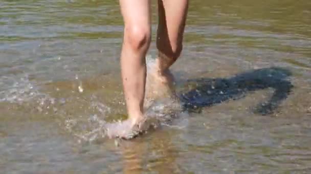 Close up view on playful kid legs running on wet sand σε ρηχά νερά στην παραλία νιώθοντας θετικά συναισθήματα. Full HD βίντεο αργής κίνησης. Καλοκαιρινές διακοπές — Αρχείο Βίντεο