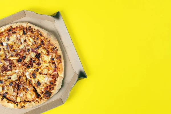 Tasty hawaii pizza in a box isolated on yellow Top view on paperoni pizza. Concept for italian food, street food, fast food, quick bite. Banner with copy space.