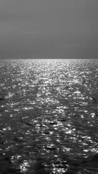 Vista sobre el mar tranquilo o el océano y el cielo con hermoso reflejo del sol por la noche. Paisajes vista de agua de mar sin fin. Video en blanco y negro. Vídeo en cámara lenta Full HD — Vídeos de Stock