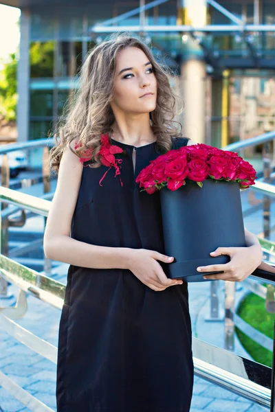 Meisje met boeket van rode rozen — Stockfoto