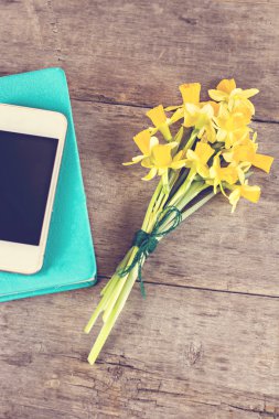 Masanın üzerinde bir zarf içinde sarı nergis