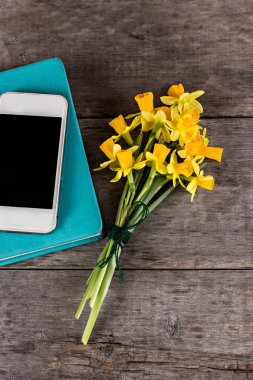 Masanın üzerinde bir zarf içinde sarı nergis