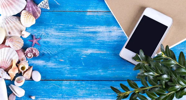 Tablet, deniz kabuklarını, mavi ahşap arka plan