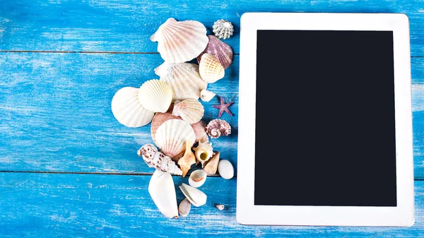 Tableta, conchas marinas, fondo de madera azul — Foto de Stock
