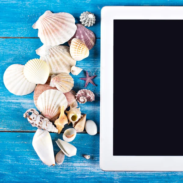 Tableta, conchas marinas, fondo de madera azul — Foto de Stock