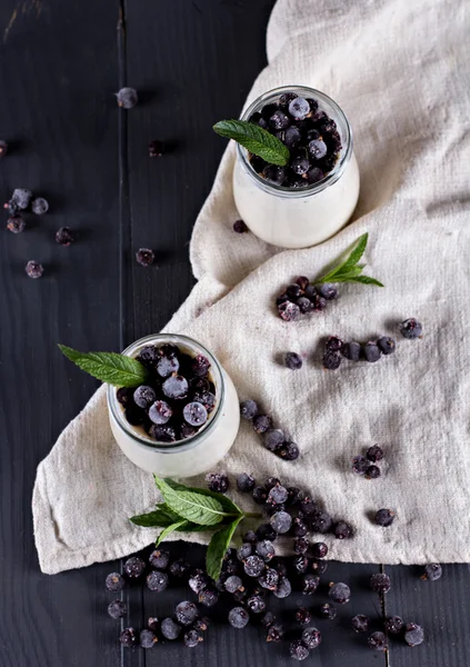 Iogurte natural com uma passa de Corinto preta . — Fotografia de Stock