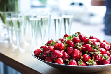 Çilek ve şampanya bardağı masada yemek.