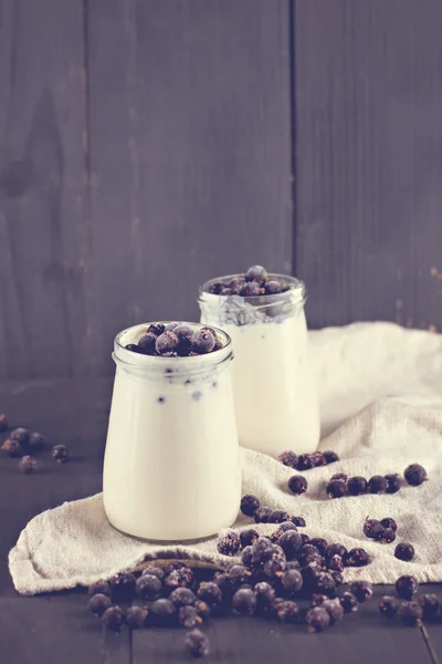 Naturell yoghurt med en svart vinbär. — Stockfoto