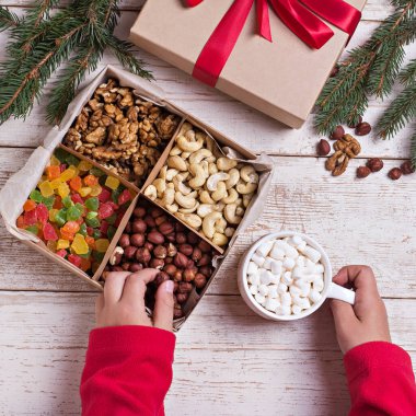 Eski ahşap arka planda bir kutu fındık ve kurutulmuş meyve. Fındık, kaju, kurutulmuş baba, kurutulmuş ananas.. 