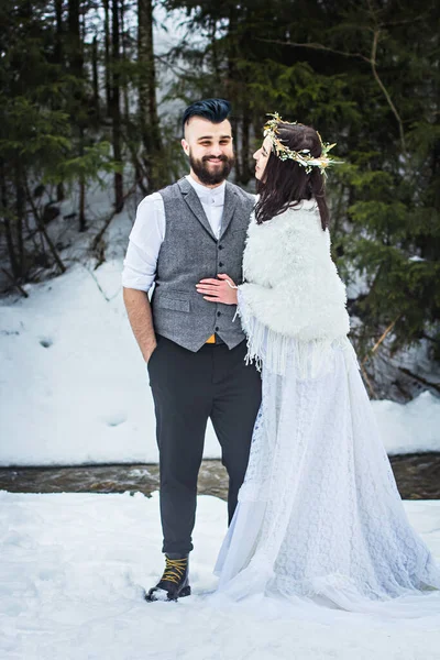 Novia y novio en el invierno en la cima de la montaña. Boda feliz pareja snowboarders acaba de casarse en la montaña. —  Fotos de Stock