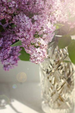 Penceresinde bir buket leylak olan vazo. Beyaz ve pembe leylak yakın plan. Güneş ışığının altında pencerenin üzerinde bir buket çiçek. Leylak buketi. 