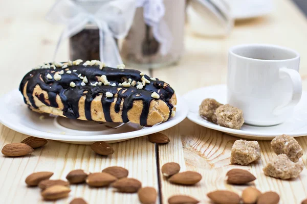 Pastel de chocolate (eclair) con taza de café. profiteroles con crema de chocolate —  Fotos de Stock