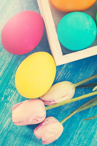 Velikonoční složení. Velikonoční vajíčka a květiny na stole. — Stock fotografie