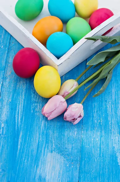 Velikonoční složení. Velikonoční vajíčka a květiny na stole. — Stock fotografie