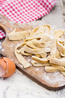 Ev yapımı makarna, makarna veya erişte ahşap masa üzerinde. Hazırlık