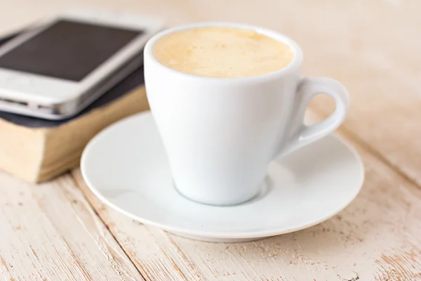 Uma xícara de café "espresso", macaroon e um telefone . — Fotografia de Stock