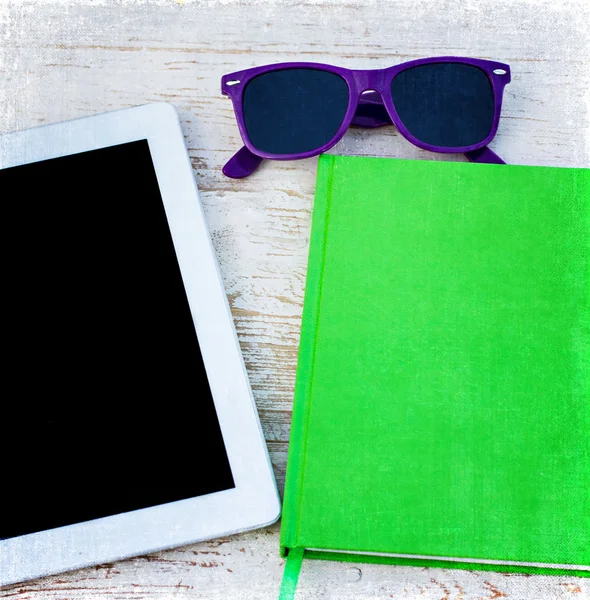 Cuaderno, tableta y gafas de sol en una mesa de madera —  Fotos de Stock