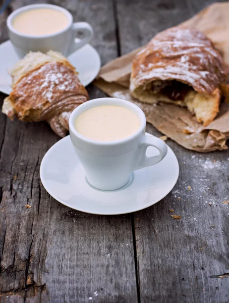 A cup of coffee "espresso" and croissant on the wooden table. — Stock Photo, Image