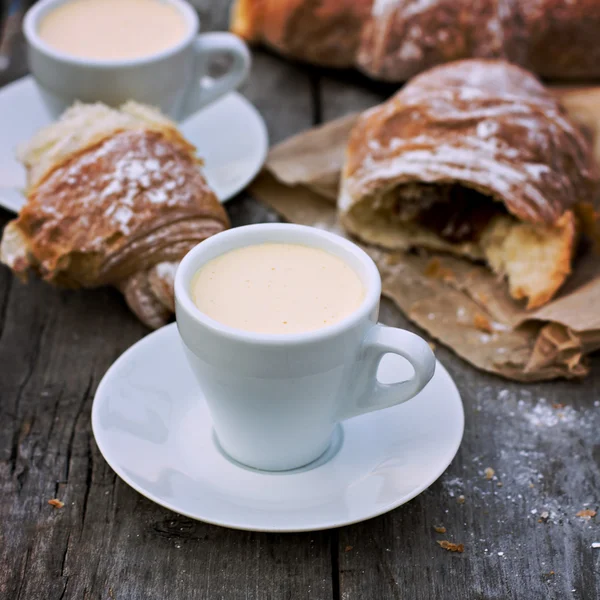 A cup of coffee "espresso" and croissant on the wooden table. — Stock Photo, Image