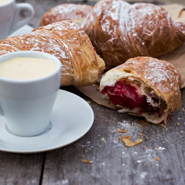 A cup of coffee "espresso" and croissant on the wooden table. Tonned photo. — Stock Photo, Image