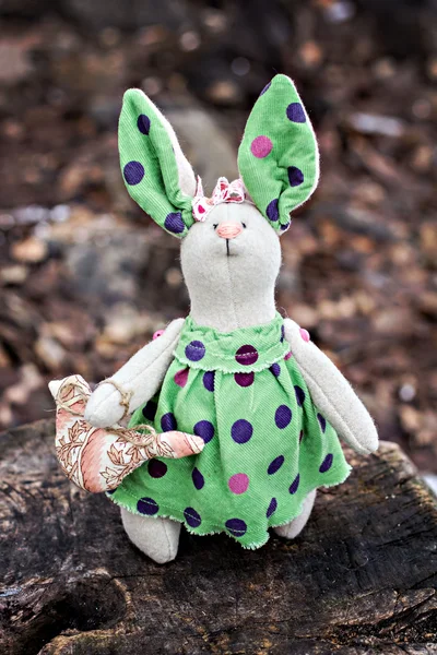 Мягкая игрушка - кролик сидит на старом дереве . — стоковое фото