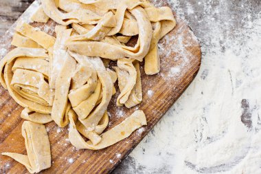 Ev yapımı makarna, makarna veya erişte ahşap masa üzerinde. Hazırlık