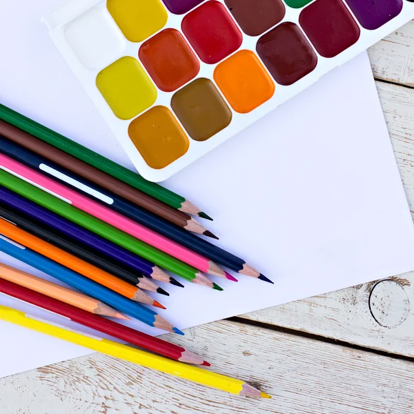 Colored pencils, water colors and paper on the desk — Stock Photo, Image