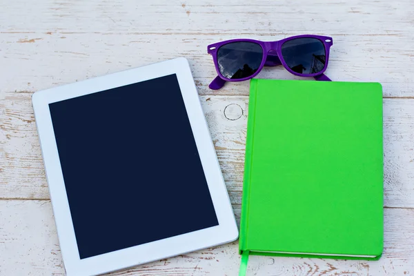 Notebook, mobile phone and sunglasses on a wooden table — Stock Photo, Image