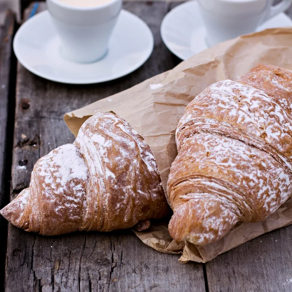 A cup of coffee "espresso" and croissant on the wooden table. — Stock Photo, Image