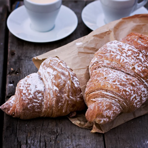 Een kopje koffie "espresso" en croissant op houten tafel. Tonned foto. — Stockfoto