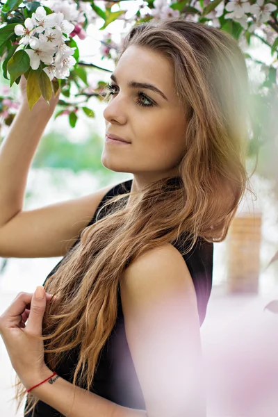 Kvinne i vårblomst. Ung, naturlig vakker kvinne nær det blomstrende treet om våren. Miljøskjønnhet og helsebegrep . – stockfoto