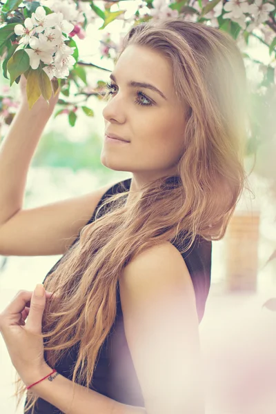 Kvinne i vårblomst. Ung, naturlig vakker kvinne nær det blomstrende treet om våren. Miljøskjønnhet og helsebegrep . – stockfoto