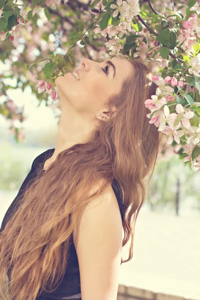 Nainen kevään kukassa. Nuori luonnostaan kaunis nainen lähellä kukkivaa puuta keväällä. Eco kauneus ja terveys käsite . — kuvapankkivalokuva