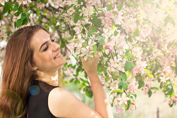 Vrouw in voorjaar bloei. Jonge natuurlijk mooie vrouw in de buurt van de bloeiende boom in het voorjaar. Eco-concept voor schoonheid en gezondheid. — Stockfoto