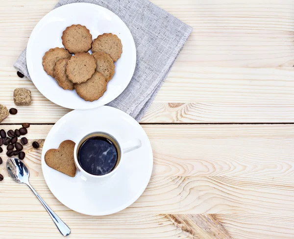 Ingwerkekse, Zimt, eine Tasse heißen Kaffee. Walnüsse, Haselnüsse auf Holzgrund — Stockfoto