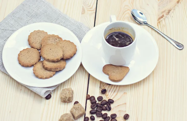 Ingwerkekse, Zimt, eine Tasse heißen Kaffee. Walnüsse, Haselnüsse auf Holzgrund — Stockfoto