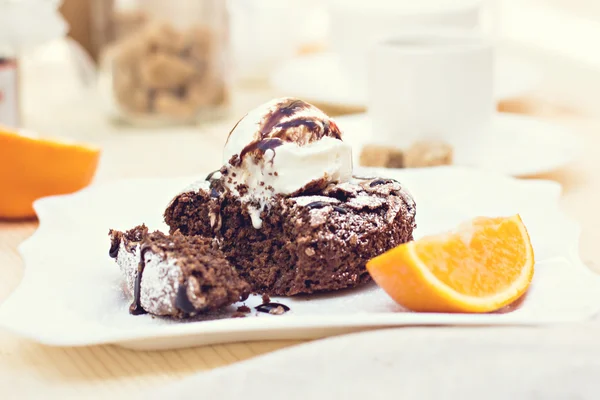 Тёплый десертный шоколадный торт Fondant подается на тарелке с мороженым, миндальными чипсами, мятой, глазурью, цитроном, какао — стоковое фото